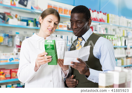 woman pharmacist discussing prescription medicines with man woman pharmacist discussing prescription medicines with man 41885923
