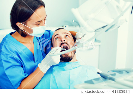 Stomatologist girl in uniform is taking visional inspection of a man 41885924