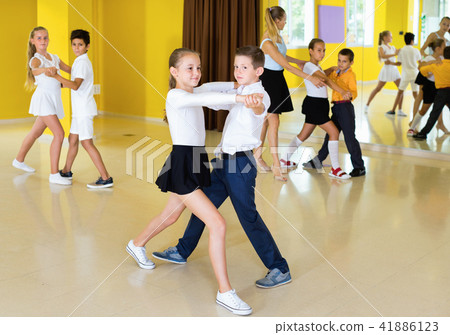 Little boys and girls having dancing class in classroom Little boys and girls having dancing class in classroom 41886123
