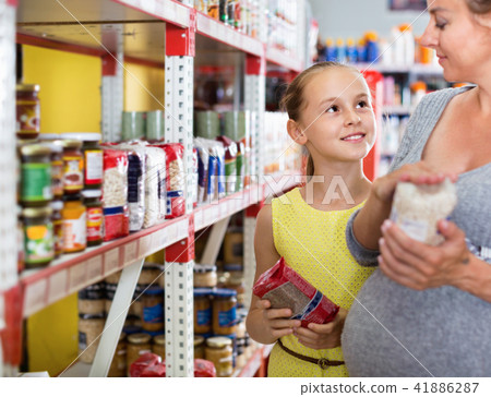 Woman with daughter are choosing fresh goods in food department Woman with daughter are choosing fresh goods in food department 41886287