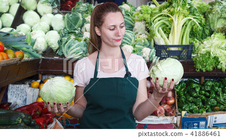 Seller is holding green cabbage on her workplace Seller is holding green cabbage on her workplace 41886461