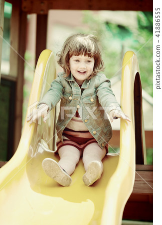 Happy two-year girl in jacket on slide 41886555