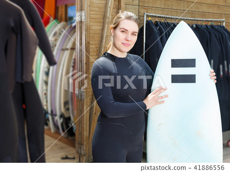 woman dressed in water suit holding surfboard 41886556