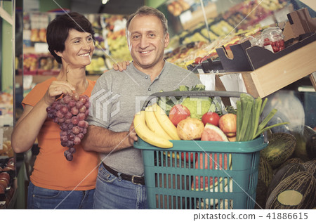 Couple demonstraiting basket with goods Couple demonstraiting basket with goods 41886615