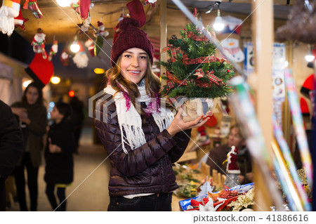 Woman customer choosing Christmas tree outdoor Woman customer choosing Christmas tree outdoor 41886616