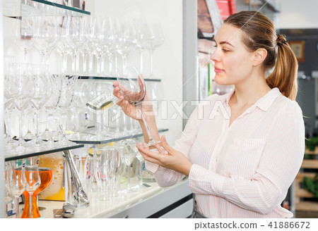 Female customer choosing wineglass in the tableware store Female customer choosing wineglass in the tableware store 41886672