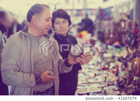 Senior couple looking vintage souvenirs at flea market 41887074