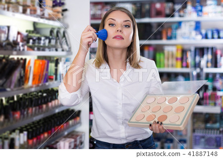 girl applying powder with brush for testing 41887148
