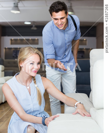 smiling man and woman are choosing sofa in store smiling man and woman are choosing sofa in store 41887168