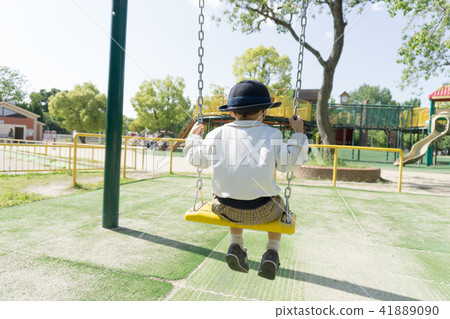 A kindergarten child playing with a swing in a par A kindergarten child playing with a swing in a par 41889090