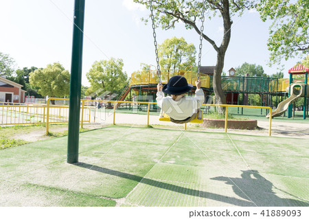 A kindergarten child playing with a swing in a par 41889093