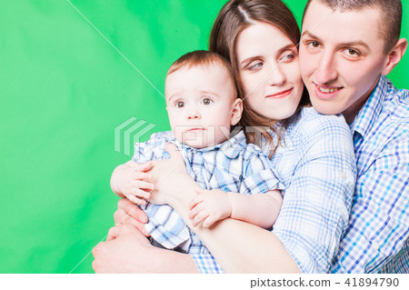 Young family portrait isolated on a green background Young family portrait isolated on a green background 41894790