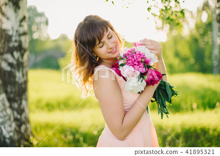 happy smiling girl with flower bouquet outdoors in summer 41895321