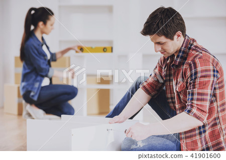 Young Couple Assembling Furniture in New Home. 41901600