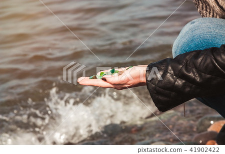 Woman picking sea finds on shore Woman picking sea finds on shore 41902422