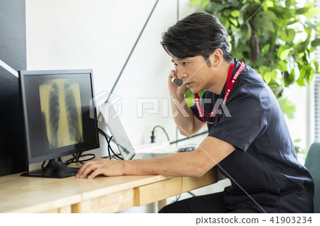 Male doctor looking at X-ray while talking 41903234