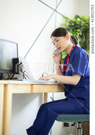 Female physician entering pc while talking Female physician entering pc while talking 41903765