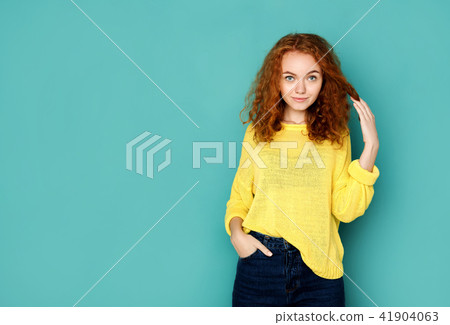 Cheerful girl in casual clothes posing at studio 41904063