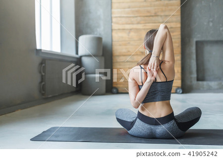 Young woman in yoga class, back stretching Young woman in yoga class, back stretching 41905242