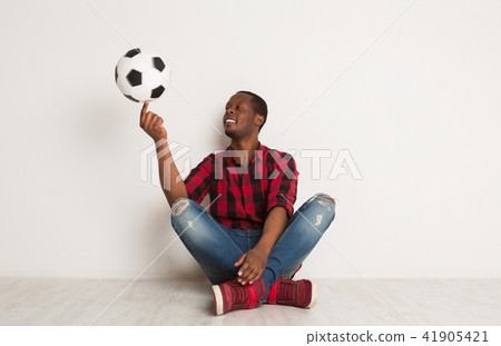 Happy smiling black man spinning ball on his finger 41905421