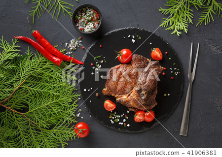 Rib eye steak on dark plate, top view Rib eye steak on dark plate, top view 41906381