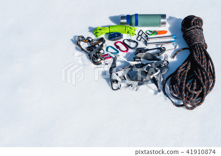 Winter set of equipment of an ice climber with carabiner wounds and a camp thermos. Copy space for Winter set of equipment of an ice climber with carabiner wounds and a camp thermos. Copy space for 41910874
