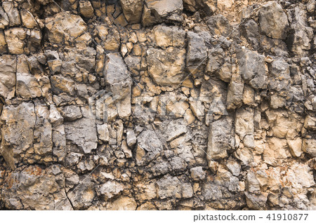 Pebble stones in a rocky wall. Natural background of a rocky stone wall Pebble stones in a rocky wall. Natural background of a rocky stone wall 41910877