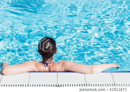 Beautiful woman relaxing in a swimming pool 41911671