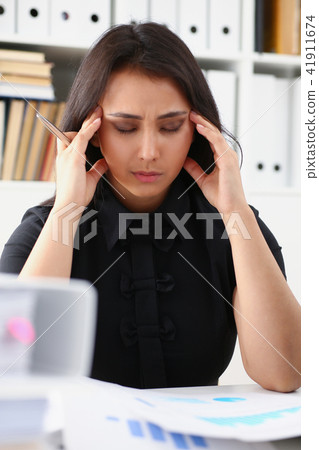 Tired and exhausted woman looks at documents propping up her head with her hands 41911674
