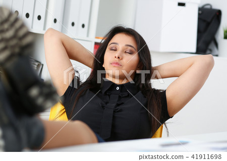pretty young woman in office sit at table finish all the work have a break can afford to relax pretty young woman in office sit at table finish all the work have a break can afford to relax 41911698