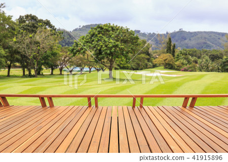 Hardwood decking or flooring and view of green field in golf course. Garden decorative 41915896