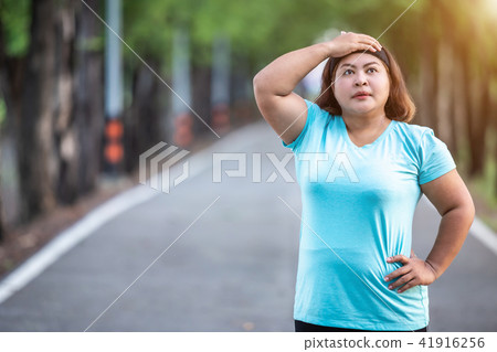 Fat woman feeling tired while running in the park 41916256