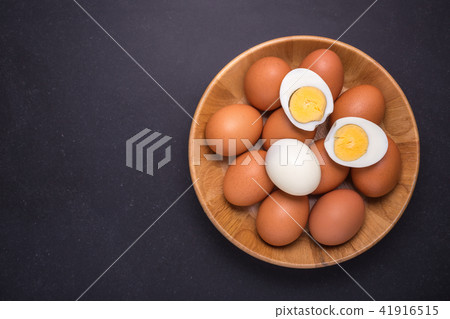 Fresh egg and boiled egg without shell. Top view on black stone 41916515