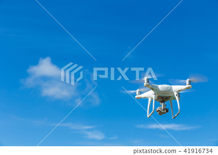 Flying drone quadcopter with digital camera on blue sky Flying drone quadcopter with digital camera on blue sky 41916734