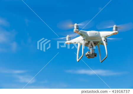 Flying drone quadcopter with digital camera on blue sky Flying drone quadcopter with digital camera on blue sky 41916737