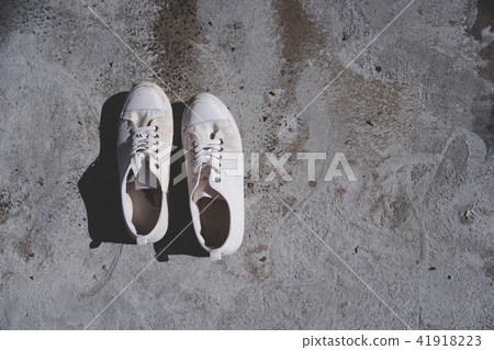 white sneaker shoes on cement floor white sneaker shoes on cement floor 41918223