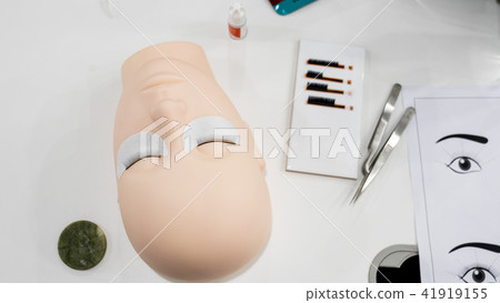 eyelashes on a silicone mannequin and tweezers 41919155