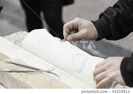 Man carving stone 41919912