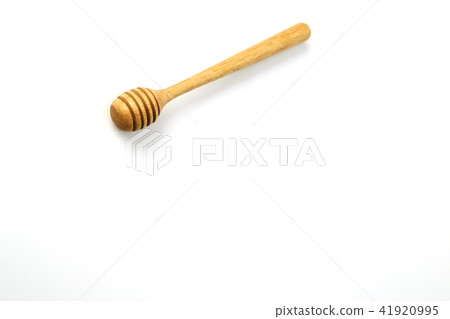 Honey dripping from a wooden honey dipper Honey dripping from a wooden honey dipper 41920995