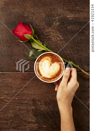 The hand of a young woman holding a red coffee The hand of a young woman holding a red coffee 41921334