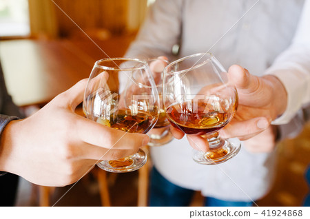 Group of friends a toast to the cheers of cognac or brandy Group of friends a toast to the cheers of cognac or brandy 41924868