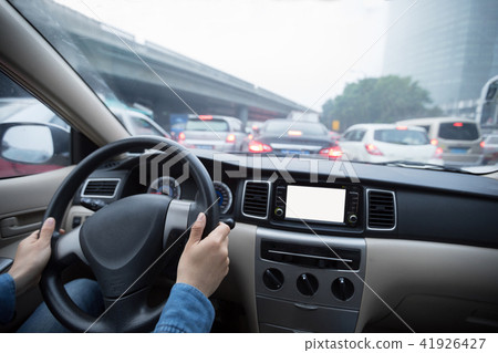 Hands on wheel driving car in traffic jam city 41926427