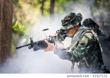 Squad of soldiers patrolling across deep forest. 41927132