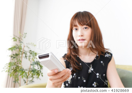 A woman watching TV at home A woman watching TV at home 41928669
