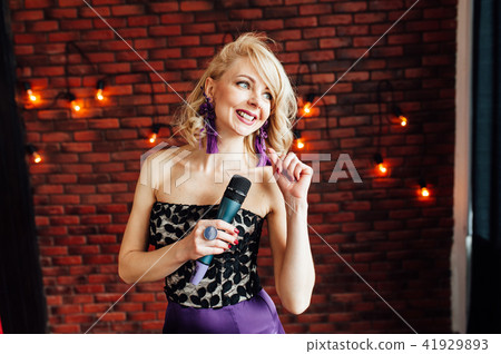 beautiful girl leading holding a microphone and smiling 41929893