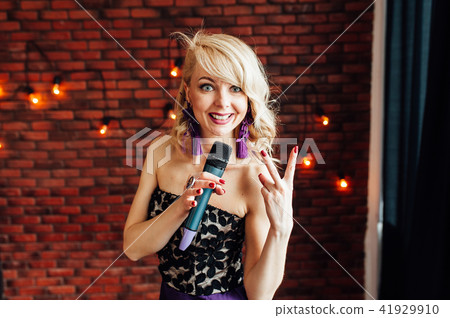 beautiful girl leading holding a microphone and smiling 41929910