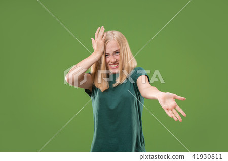 Beautiful female half-length portrait isolated on green studio backgroud. The young emotional 41930811