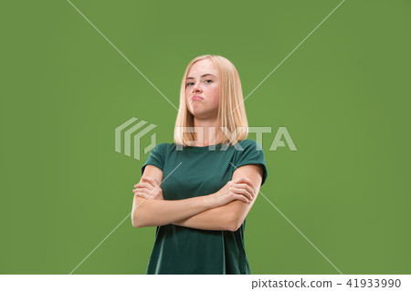 Suspiciont. Doubtful pensive woman with thoughtful expression making choice against green background Suspiciont. Doubtful pensive woman with thoughtful expression making choice against green background 41933990