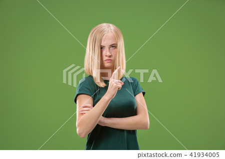 Suspiciont. Doubtful pensive woman with thoughtful expression making choice against green background Suspiciont. Doubtful pensive woman with thoughtful expression making choice against green background 41934005