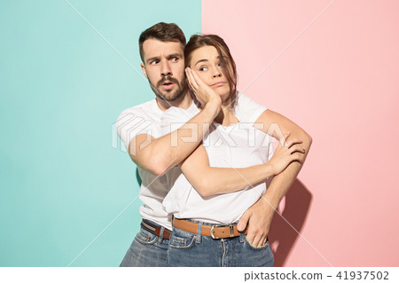 Wow. Doubtful pensive couple with thoughtful expression making choice against pink background Wow. Doubtful pensive couple with thoughtful expression making choice against pink background 41937502